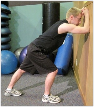 Standing calf stretch against the wall, position 1.