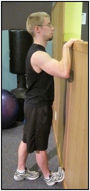 Standing calf stretch  with foot against the wall, position 1.